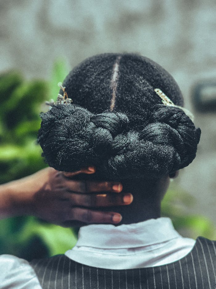 Detailed view of a stylish braided updo adorned with decorative hairpins.